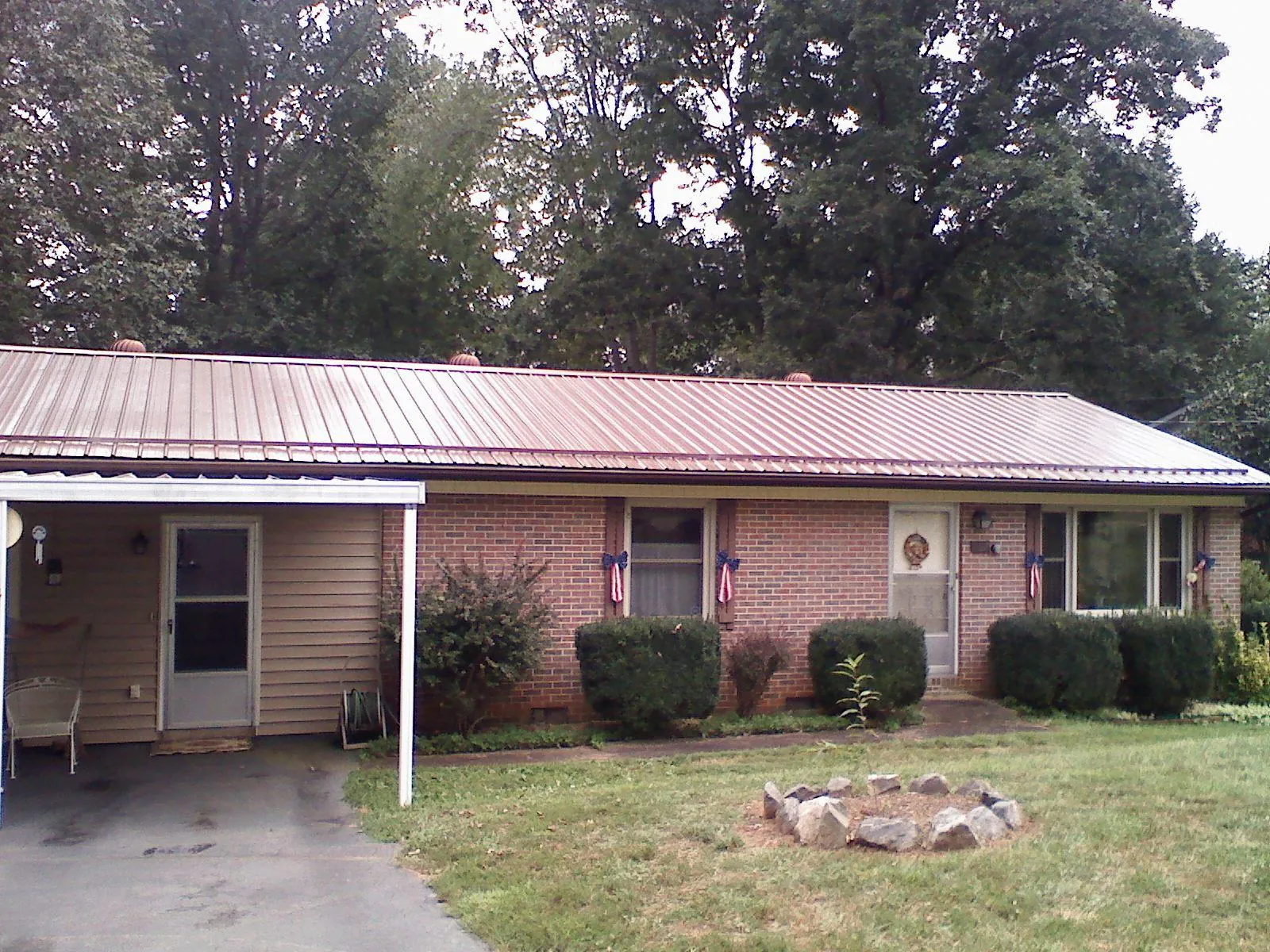 Bronze metal roof and carport on a brick ranch home — Roof Repair work by our crew in Whitestone